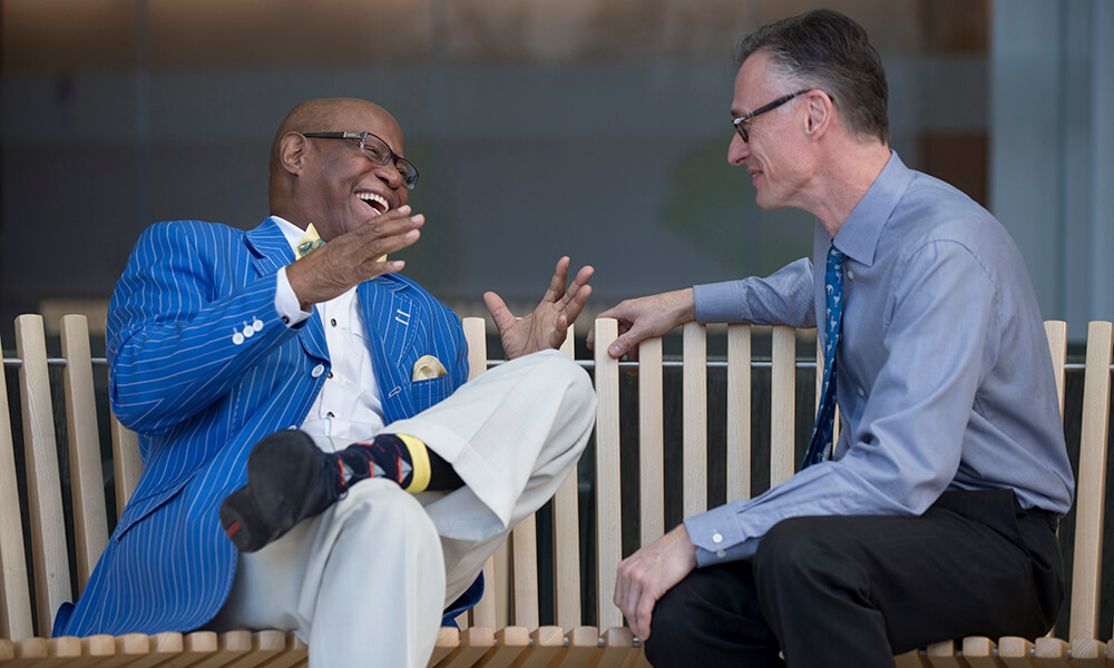 Willie Murphy laughing as he sits on a park bench and tells Jean Coumans a story Willie Murphy laughing as he sits on a park bench and tells Jean Coumans a story